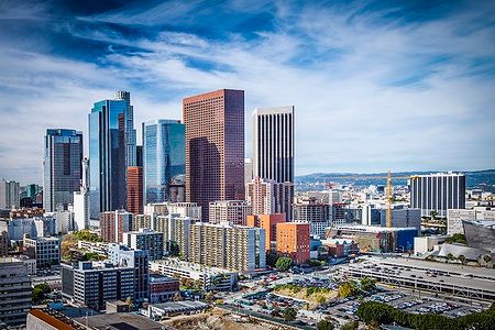 Skyline di grattacieli a Downtown Los Angeles sotto un cielo azzurro.