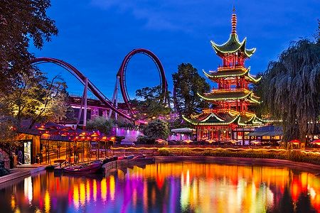 Tivoli Gardens a Copenhagen di sera con luci colorate e pagoda.