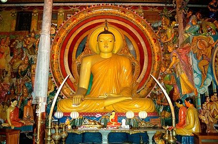 Statua del Buddha in un tempio a Colombo, Sri Lanka, circondata da colori vivaci.