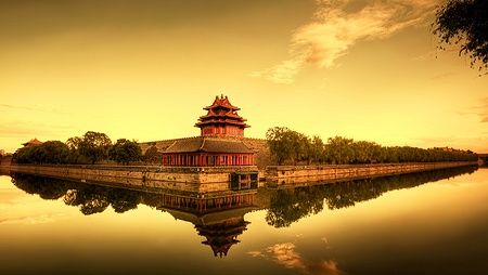 Vista della Città Proibita di Pechino al tramonto con riflessi sull'acqua.