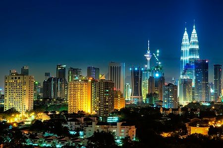 Skyline notturno di Kuala Lumpur con le Petronas Twin Towers illuminate.