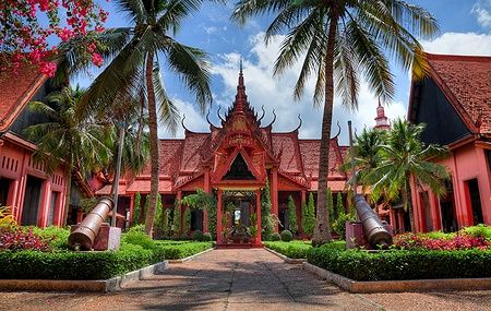 Giardino interno del National Museum a Phnom Penh con palme e architettura tradizionale.
