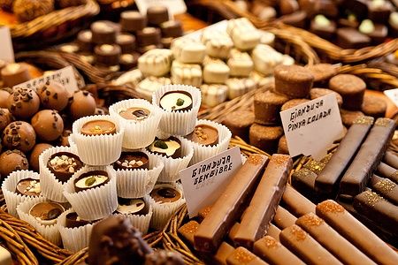 Diversi tipi di cioccolatini disposti in fila nelle ceste.