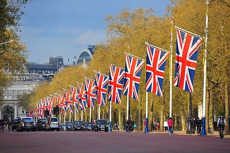 Bandiere del Regno Unito su The Mall a Londra con taxi e persone.