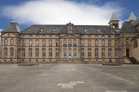 Vista frontale dell'Abbazia di Echternach in Lussemburgo con cielo azzurro.