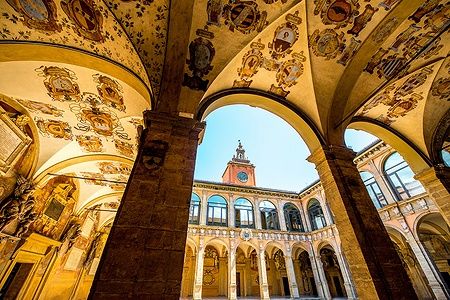 Cortile dell'Archiginnasio di Bologna con archi e volte dipinte.