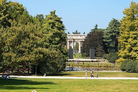 Arco della Pace a Milano visto dal Parco Sempione con persone passeggianti.