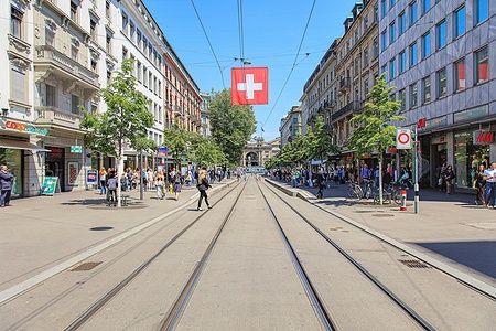 Veduta della Bahnhofstrasse a Zurigo, con negozi e persone lungo la strada.