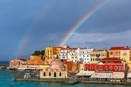 Doppio arcobaleno sopra il vecchio porto di Chania, Creta, con moschea storica.