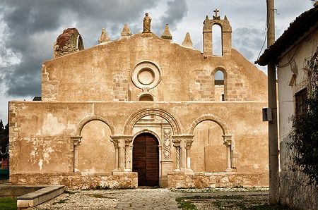 Facciata della chiesa di San Giovanni a Siracusa con cielo nuvoloso.