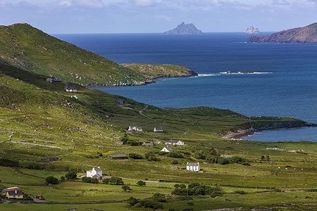 Costa panoramica del Ring of Kerry in Irlanda con colline verdi e mare blu.
