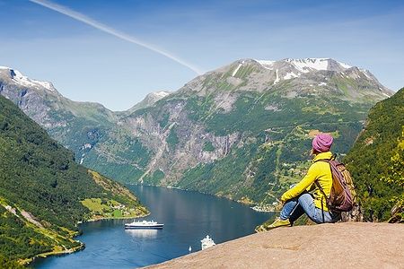 Giovane donna ammirando il paesaggio del fiordo di Geiranger, Norvegia.
