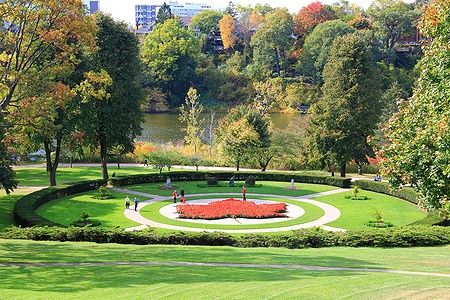 Vista di un giardino ad High Park, Toronto, con alberi autunnali colorati e persone che passeggiano.