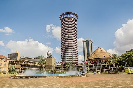 Kenyatta International Conference Centre a Nairobi, Kenya, con cielo blu e bandiere.