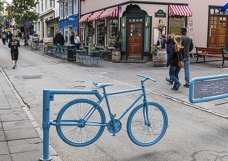 Bicicletta blu su strada Laugavegur a Reykjavik con persone e locali.