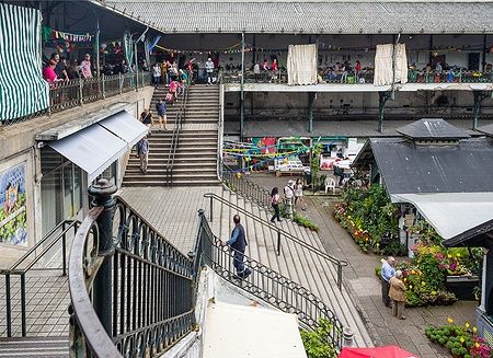 Interno storico del Mercado do Bolhão a Porto, con persone e bancarelle.