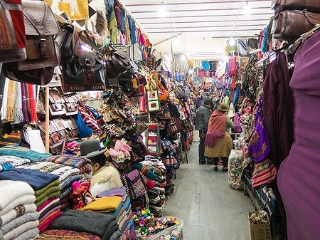 Mercato turistico su Sagarnaga street a La Paz con prodotti artigianali colorati.