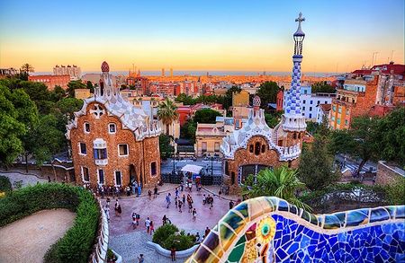 Panorama di Park Güell a Barcellona al tramonto con persone in visita.