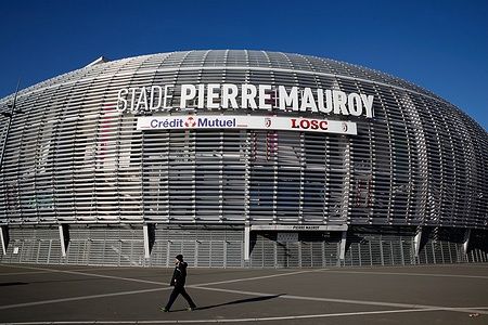Pierre Mauroy Stadium con una persona che cammina davanti in una giornata limpida.