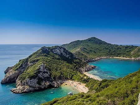 Vista panoramica sulla spiaggia di Porto Timoni a Corfù con mare turchese e colline verdi.
