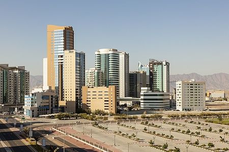 Grattacieli nel centro di Fujairah con montagne sullo sfondo.