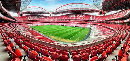 Stadio da Luz a Lisbona con gradinate rosse e campo da calcio verde.