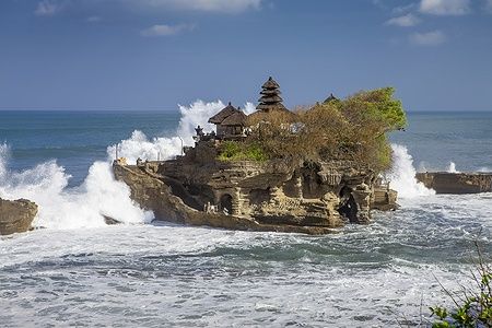 Tempio di Tanah Lot a Bali con grandi onde che si infrangono.