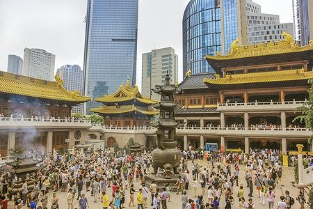 Folla di fedeli nel tempio buddhista Jing'an a Shanghai tra moderni grattacieli.