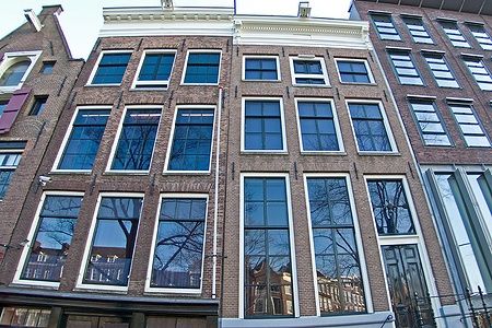 Facciata della Casa di Anne Frank ad Amsterdam con grandi finestre.