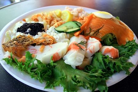 Piatto di plastica con specialità di mare norvegese e verdure fresche.