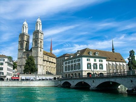 Grossmünster a Zurigo vicino al fiume Limmat sotto un cielo azzurro.