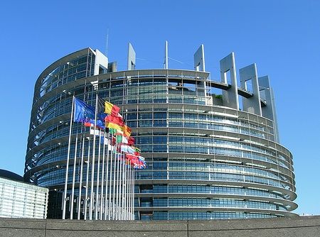 Edificio del Parlamento Europeo a Strasburgo con bandiere europee.