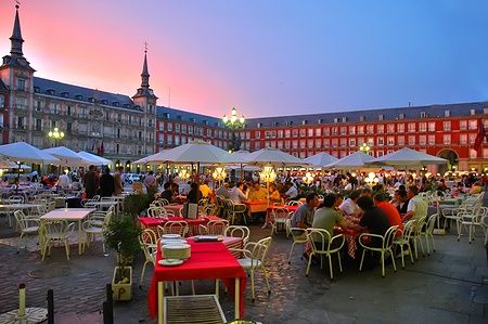 Plaza Mayor a Madrid con persone che cenano al tramonto.