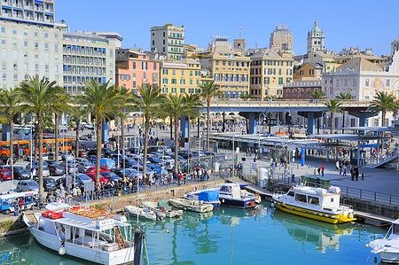 Porto Antico di Genova con barche e edifici colorati sullo sfondo.