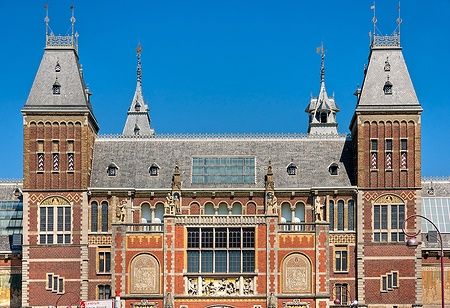 Facciata del Rijksmuseum ad Amsterdam sotto un cielo azzurro.