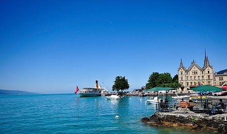 Vista del lago di Ginevra a Vevey con battello e edificio storico.