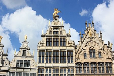 Facciate di case monumentali nella Grand Place di Anversa con cielo blu.
