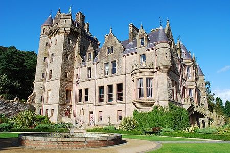 Belfast Castle in un giorno soleggiato, circondato da giardini curati.
