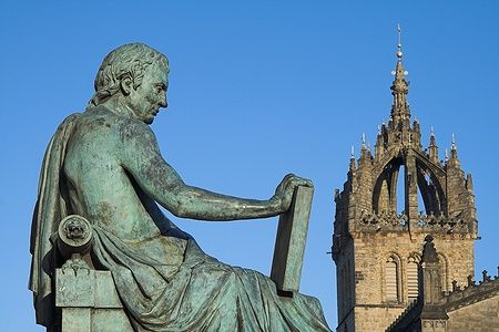 Statua di David Hume con la Cattedrale di St Giles a Edimburgo sullo sfondo.