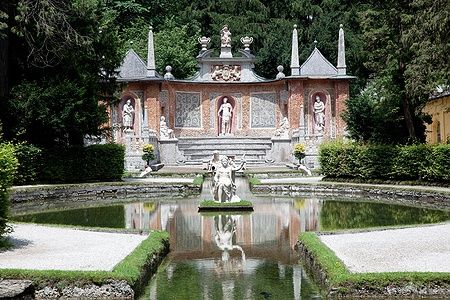 Fontana nei Giardini di Hellbrunn a Salisburgo con statue e specchio d'acqua.