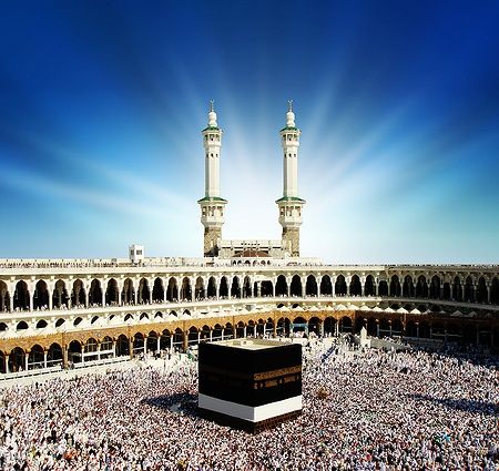 La Kaaba a Mecca, circondata da pellegrini contro un cielo luminoso.