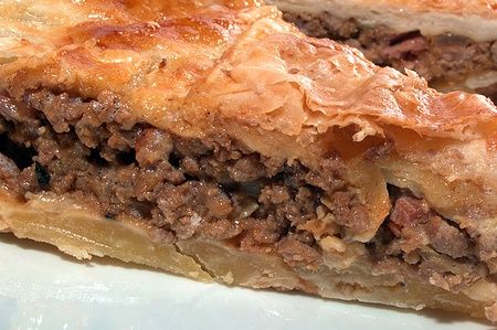 Meat pie australiana con bacon e cipolla tagliata a fette.