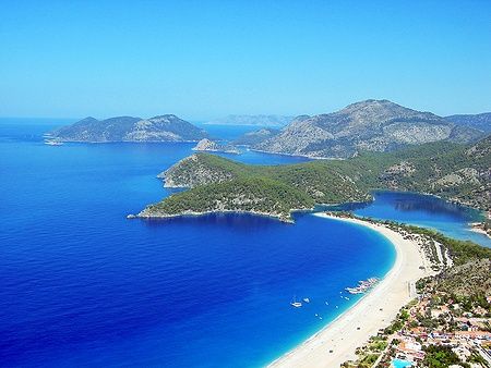 Vista della spiaggia e baia di Oludeniz in Turchia con mare blu e montagne.