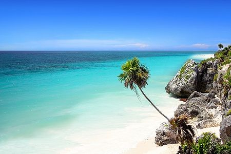 Spiaggia tropicale a Tulum con sabbia bianca e mare cristallino.