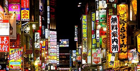 Vivaci cartelli al neon nel quartiere a luci rosse di Tokyo di notte.