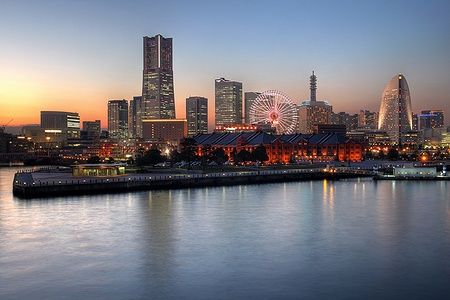 Skyline di Yokohama con tramonto e attrazioni iconiche.