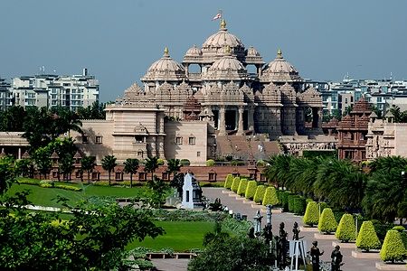 Vista del tempio Akshardham a Delhi circondato da giardini e statue.