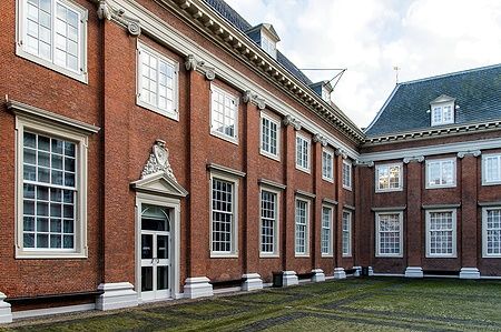 Facciata dell'Amsterdam Museum con mattoni rossi e grandi finestre.