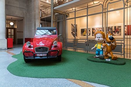 Citroën 2CV rossa e sculture di fumetti al Belgian Comic Strip Center.