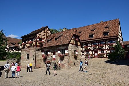 Persone nel cortile del Castello Imperiale di Norimberga in una giornata soleggiata.